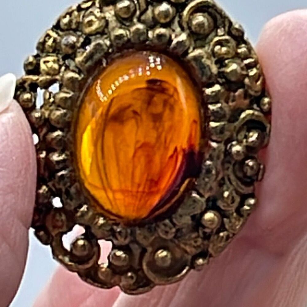 Vintage ornate amber colored brooch.